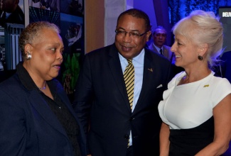 Minister of Industry, Investment and Commerce, Anthony Hylton in conversation with Chief Executive Officer of the Jamaica Business Development Corporation (JBDC), Valerie Veira (left) and President of the Jamaica Public Service, Kelly Tomblin during ‘JAMPRO’s 25th anniversary business mixer held on Wednesday, May 8 at its head offices in Kingston.