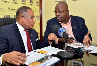 Minister of Industry, Investment and Commerce, Hon. Anthony Hylton (left); in conversation with Deputy Chief Executive Officer, Jamaica Business Development Corporation (JBDC), Harold Davis; at a Jamaica Information Service (JIS) ‘Think Tank’ session, held at the agency’s head office in Kingston, where he provided details on the Micro, Small and Medium Enterprise (MSME) Entrepreneurship Policy, which was passed in Parliament in July.