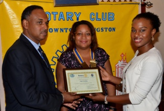 Managing Director of the Jamaica Social Investment Fund (JSIF), Mr. Omar Sweeney (left), accepts a certificate of appreciation from a member of the Rotary Club of Downtown Kingston, Ms. Kahmile Reid (right), following his presentation at a meeting of the Club on Wednesday, February 3, at the Hotel Four Seasons. President of the Club, Ms. Melanie Reece (centre), shares in the moment.