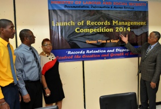 Minister of Labour and Social Security, Hon. Derrick Kellier (right), launches the Documentation, Information and Access Services Unit (DIAS) Records Management Competition 2014, during a ceremony at the Ministry’s North Street offices on December 18. Also sharing in the moment are (from left): Registrar, Documentation, Information and Access Services Unit (DIAS), in the Ministry, Winston Walker; Chief Technical Director, Ministry, Errol Miller; and Records Manager, University of the West Indies, Sonia Black.