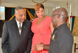 Minister of Labour and Social Security, Hon. Derrick Kellier (left), listens to a comment from Chairman of the Golden Age Home in Kingston, Fabian Brown, while attending a recent Christmas treat at the institution. At centre is General Manager of the home, Laurette Adams-Thomas.