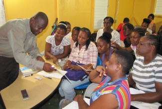 Teacher at the Kitson Town Seventh Day Adventist Evening Institute, in St. Catherine, Wycliffe Brown (left), conducts a session with his students. 