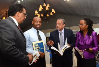 President of the Library and Information Association of Jamaica (LIAJA), Matthew Blake (2nd left), emphasises a point during discussion with (from left): Deputy Director General, Corporate Governance and Management, Planning Institute of Jamaica (PIOJ), Kirk Philips; Director General of the Planning PIOJ, Collin Bullock; and Permanent Secretary in the Ministry of Education, Elaine Foster Allen at the opening of the two-day PIOJ/ LIAJA conference on January 30, at the Terra Nova Hotel in Kingston.