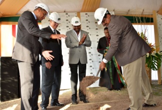 Tourism and Entertainment Minister, Hon. Dr. Wykeham McNeill (right), performs the symbolic groundbreaking exercise signaling the commencement of construction of the Courtyard  Marriott Hotel during a ceremony at the project site in New Kingston in July. Observing (from left) are: Leader of the Opposition, Andrew Holness; Chairman, Pan Jamaican Investment Trust (Pan-Jam) and Director, Caribe Hospitality Jamaica, Stephen Facey; Opposition Spokesman on Tourism and Travel Service Development, Edmund Bartlett; and Rector, St. Andrew Parish Church, Rev. Canon Major Sirrano Kitson.