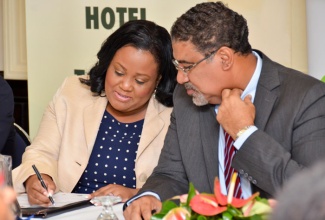 Minister of Tourism and Entertainment, Hon. Dr. Wykeham McNeill (right) converses with Minister with responsibility for Sport, Hon. Natalie Neita Headley during the official launch of Jamaica Sport on Wednesday (October 1), at the Courtleigh Hotel and Suites in New Kingston.