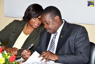 Minister of National Security, Hon. Robert Montague (right), in discussion with Executive Director, Institute of Forensic Science and Legal Medicine, Dr. Judith Mowatt, at the handing over of the BULLETTRAX-3D system to the Institute, in Kingston, today (March 14).   