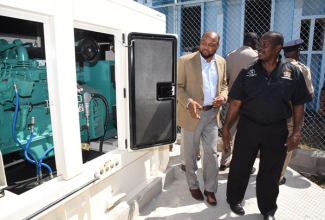 Minister of National Security, Hon. Robert Montague (right), and Mayor of St. Ann's Bay, His Worship Michael Belnavis, look at the new standby generator installed at the Ocho Rios Police Station in St. Ann.  The Minister officially handed over the equipment on August 31.