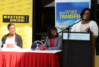 Minister with responsibility for Sport, Hon. Natalie Neita Headley, addresses  a ceremony on January 9 at the Knutsford Court Hotel in New Kingston, to announce GraceKennedy Money Services’ (GKMS) sponsorship of Olympian and national swimming champion, Alia Atkinson. Listening (from left) are Miss Atkinson; and Chief Executive Officer at GKMS, Michelle Allen.