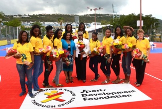 Minister with responsibility for Sports, Hon. Natalie Neita Headley (fifth left); and President, Jamaica Netball Association, Marva Bernard (centre) pose with members and management of the Sunshine Girls team during the official reopening of the newly resurfaced Leila Robinson netball courts on Thursday, August 7, located at Independence Park Complex, National Arena in Kingston. 