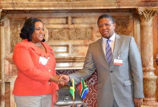 Minister without Portfolio with Responsibility for Sport, Hon.Natalie Neita Headley (left) shakes hands with South African Minister of Sport, Fikile Mbalula (right), after the two signed a sporting agreement in Glasgow, Scotland on Monday (July 21). The agreement will see both countries promoting and strengthening bilateral relations and cooperation in sport. Minister Neita Headley is currently in Glasgow at the 20th Commonwealth Games from July 23 to August 3.