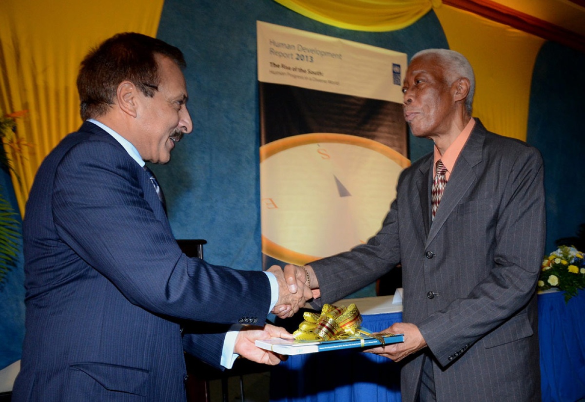 Foreign Affairs and Foreign Trade Minister, Senator the Hon. A.J Nicholson (right), is presented with a copy of the United Nations Development Programme (UNDP), Human Development Report (HDR), entitled: ‘The Rise of the South: Human Progress in a Diverse World,’ by UNDP Resident Representative in Jamaica, Dr. Arun Kashyap. Occasion was Tuesday’s (June 4) national launch of the publication at the Jamaica Pegasus Hotel, New Kingston.