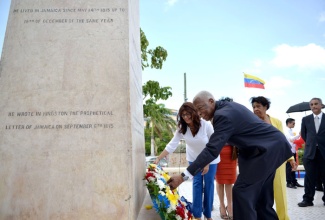 Minister of Foreign Affairs and Foreign Trade, Hon. A.J. Nicholson (right)  and   Venezuelan Ambassador to Jamaica,  Her Excellency Maria Jacqueline Mendoza (left), lay a wreath at the monument of Simon Bolivar, at Bolivar Square, National Heroes Circle on Friday, July 24, to commemorate the  birthday of Simon Bolivar.  