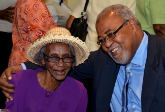 President of the Jamaica Government Pensioners Association, Charles Jones (right), hugs retired teacher of English and remedial reading specialist, Iris Burtess Salmon, during the association’s 47th annual general meeting, held at the Knutsford Court Hotel in Kingston, on August 14. During the event, Mrs. Burtess Salmon was recognised for her invaluable service to the association.