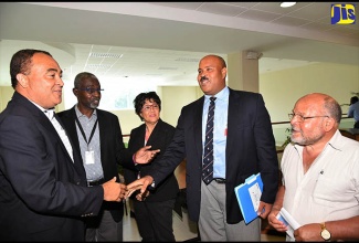 Minister of Health, Dr. the Hon.  Christopher Tufton (left), is greeted by  Director of the University of the West Indies (UWI) Epidemiology Unit, Professor Marshall Tulloch-Reid (4th left), at a forum organised by the Caribbean Institute for Health Research (CAIHR),  today (July 6), at the UWI Mona Campus, in St. Andrew. Others (from left) are Co-Investigator at the Unit, Professor Rainford Wilks; Advisor on Health System and Services at the Pan American Health Organization (PAHO), Dr. Hedwig Goede, and retired UWI Professor, Alan Jackson.