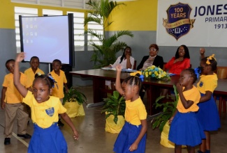 Students of the Jones Town Basic School perform an item at a special forum on primary education held today (Oct. 10), at the Jones Town Primary School in Kingston. Enjoying the performance (in background) are: Permanent Secretary in the Ministry of Education, Elaine Foster-Allen (right); Board Chairman, Jones Town Primary School, Maria Jones; and Principal, Venice Bartley. 