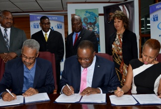 Executive Director of the HEART Trust/NTA, Dr. Wayne Wesley (seated centre); Executive Director of GSW Animation, Wayne Sinclair (seated left);and Director of GSW Animation, Favel Williams (seated right); sign a Memorandum of Understanding (MoU) for the development of animation skills, at a function held on February 24 at the HEART Trust/NTA’s Oxford Road office in Kingston. Looking on in the background (from left) are: Managing Director of the Transport Authority, Donald Foster; Director of Business Development and Workforce Solutions at the HEART Trust NTA, Mark Wallen; Senior Director, Workforce Development and Employment, Denworth Finnikin; and President of Jamaica Promotions Corporation (JAMPRO), Diane Edwards.