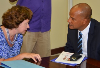 Minister of National Security, Hon. Peter Bunting (right), in conversation with Charge’ d’Affaires of the United States Embassy, Elizabeth Lee Martinez, at the launch of the Organization of American States (OAS) and Trust for the Americas Project: ‘A New Path – Promoting a Healthy Environment and Productive Alternatives for Juvenile Remandees and Offenders in Jamaica’, at the Ministry in Kingston, on  November 19.