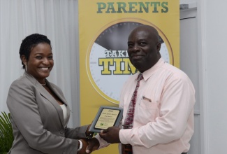 Executive Director of the National Parenting Support Commission (NPSC), Dr. Patrece Charles-Freeman (left), presents Roy Nelson with the ‘Team Spirit Award’ for outstanding performance in the parent mentors training course. Occasion was the graduation ceremony for the second cohort of parent mentors held today (November 26), at the Spanish Court Hotel, New Kingston.