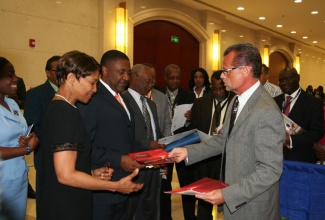 Minister of Science, Technology, Energy and Mining, and President of the Caribbean Telecommunications Union (CTU), Hon. Phillip Paulwell, (2nd left); and Secretary General of the CTU,  Bernadette Lewis (left); accept reading material on the activities of FUJITSU in the Caribbean, from President and Chief Executive Officer (CEO) for FUJITSU in the Caribbean and Central America, Mervyn Eyre (right). The Minister and other CTU officials visited the FUJITSU exhibition booth during yesterday’s (Dec. 3) opening of the 12th Caribbean Ministerial Strategic Information Communication Technology (ICT) Seminar at the Montego Bay Convention Centre in St. James.