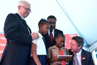 Education Minister, Rev. the Hon. Ronald Thwaites (left); Science, Technology, Energy and Mining Minister, Hon. Phillip Paulwell (centre), and Rollington Town Primary School student, Amerah Brown (2nd left), observe as Digicel Jamaica’s Chief Executive Officer, Andy Thorburn (right), demonstrates some of the features of a Huawei tablet computer presented Dujun Brown of Rennock Lodge Primary School, following Monday’s (April 8) presentation ceremony at the Port Royal Primary and Infant School, for 56 of the computers, valued just over $950,000. The tablets have been donated to seven schools in East Kingston and Port Royal, for which Mr. Paulwell is the Member of Parliament. The other institutions are: Elletson Road Primary, Windward Road Primary and Junior High, Rollington Town Primary, Holy Rosary Primary, Norman Gardens Primary, and Port Royal Primary and Infant Schools.
