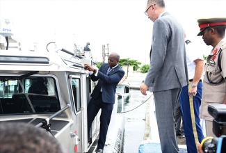 State Minister for National Security, Senator the Hon. Pearnel Charles Jr (left), boards a 38-foot SAFE boat, which was among four vessels and equipment valued at more than $500 million that have been donated to the Jamaica Defence Force Coast Guard by the United States Government under the Caribbean Basin Security Initiative. The presentation was made during a ceremony at the JDF Coast Guard headquarters in Port Royal, Kingston, on Wednesday, October 4. Looking on are Chargé d’Affaires at the United States Embassy in Jamaica, Eric Khant (right); and Chief of Defence Staff, Major General Rocky Meade (2nd right). 