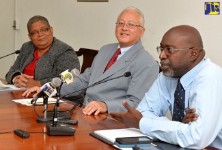 Minister of Justice, Hon. Delroy Chuck, listens to remarks from  Director of the Legal Reform Department in the Ministry, Maurice Bailey (right), at a post-Sectoral Debate Press Briefing held on May 3, at the Ministry’s Constant Spring Road offices, St. Andrew. At left is Permanent Secretary in the Ministry, Carol Palmer.