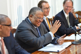 Finance and Planning Minister, Dr. the Hon. Peter Phillips (2nd left), shares a light conversation with (from left): Bank of Jamaica (BoJ) Governor, Brian Wynter; International Monetary Fund (IMF) Mission Team Chief to Jamaica, Jan Kees Martijn; and IMF Resident Representative in Jamaica, Dr. Bert van Selm, during Thursday’s (August 22) media briefing, jointly hosted by the Finance Ministry and the Mission, in Kingston. Details of the country’s just concluded first quarter performance review, under the four-year IMF Extended Fund Facility (EFF), were outlined.
