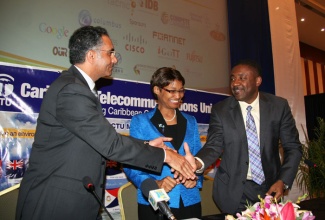 Minister of Science, Technology, Energy and Mining, and President of the Caribbean Telecommunications Union (CTU), Hon. Phillip Paulwell (right), shakes hands with Chief Executive Officer (CEO) of the Internet Corporation for Assigned Names and Numbers, Fadi Chehade, while  Secretary General of the CTU, Bernadette Lewis, shares the moment. Occasion was the signing of a Memorandum of Understanding (MOU) between the two entities, aimed at ensuring unrestricted use of the Internet by CTU member states. The signing took place on Wednesday, December 4, at the Montego Bay Convention Centre, during the 12th Caribbean Ministerial Strategic Information Communication Technology (ICT) Seminar.