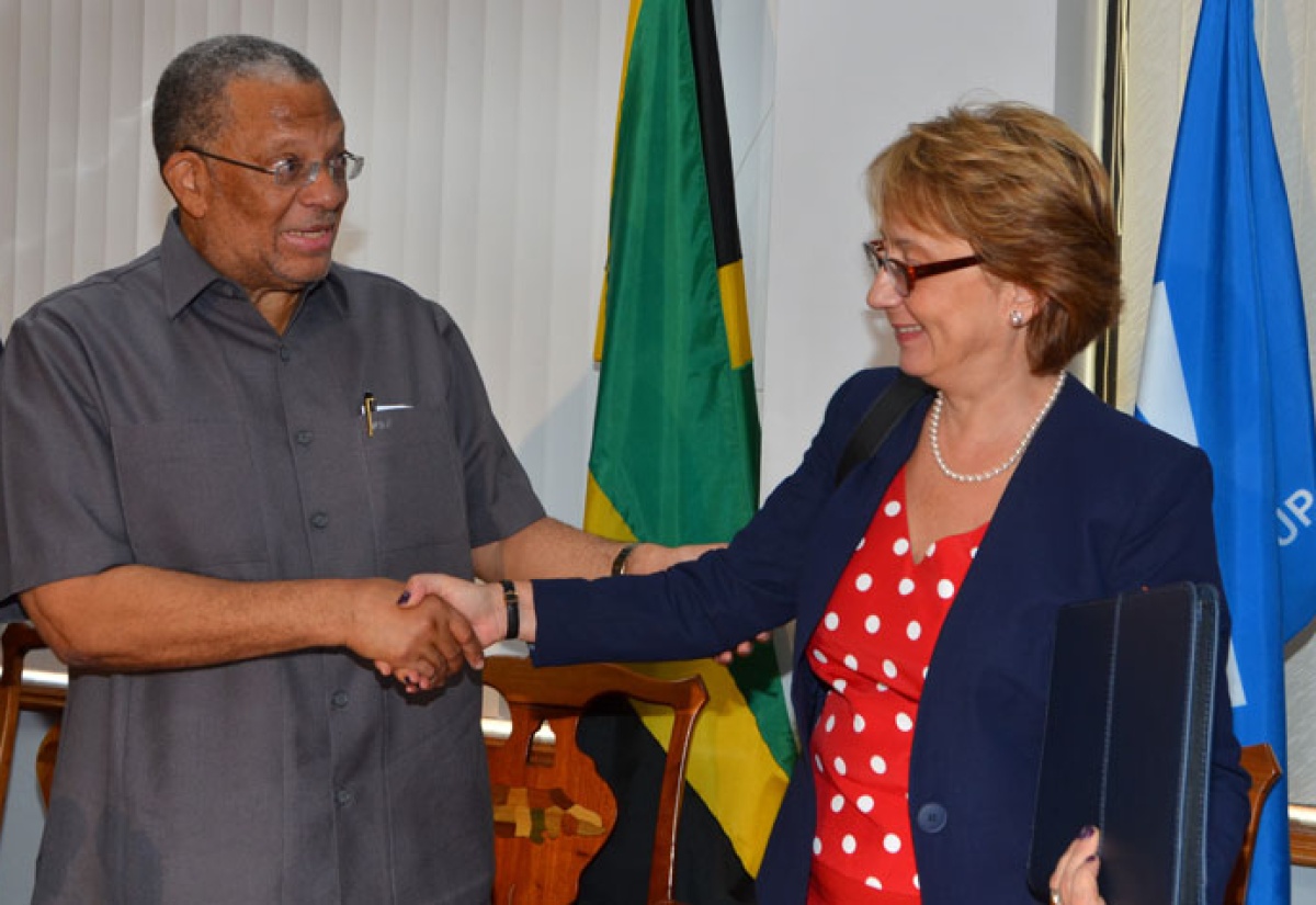 Finance and Planning Minister, Dr. the Hon. Peter Phillips (left), exchanges warm greetings with World Bank Country Manager for Jamaica, Galina Sotirova, just before Friday’s (October 2) $810.2 million (US$6.8 million) grant signing ceremony for the ‘Improving Climate Data and Information Management Project,’ at the Ministry’s offices, National Heroes Circle, Kingston.