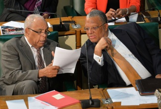 Minister of Finance and Planning, Dr. the Hon. Peter Phillips (right)
engages in conversation with Minister of Transport, Works and Housing, Dr.
the Hon. Omar Davies before closing the 2014/15 Budget debate in the House
of Representatives on April 30.
