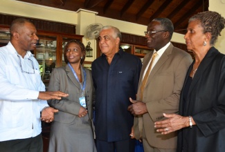 Minister of Water, Land, Environment and Climate Change, Hon. Robert Pickersgill (centre), listens to a point from Director, Meteorological Service of Jamaica, Jeffrey Spooner (left), following a press conference on January 29 at Alhambra Inn in St. Andrew, to present some of the outcomes of the 19th Conference of Parties (COP 19) to the Climate Change Conference, which was held last November in Warsaw, Poland. Others from (second left) are: Deputy Resident Representative, United Nations Development Programme (UNDP), Dr. Elsie Laurence-Chounoune; Principal Director, Climate Change Division in the Ministry, Albert Daley; and Director, Friedrich Ebert Stiftung, Judith Wedderburn.