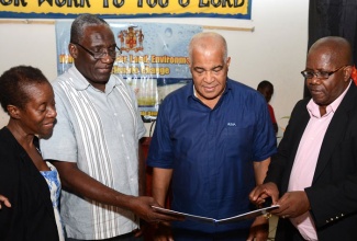 Water, Land, Environment, and Climate Change Minister, Hon. Robert Pickersgill (2nd right), along with (from left): Climate Change consultant with the Ministry’s Climate Change Division (CCD), Leonie Barnaby; Principal Director in the Division, Albert Daley (left); and Port Maria’s Mayor, Councillor Levan Freeman, peruse a copy of the Climate Change Policy Framework and Action Plan Green Paper, during the first climate change public consultation, hosted by the Ministry on Friday, February 14, at the St. Mary Parish Church Hall, Port Maria.   