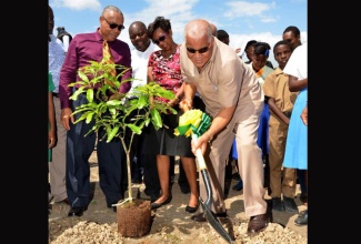 Water, Land, Environment, and Climate Change Minister, Hon. Robert Pickersgill (right), plants an East Indian mango tree during the launch of the SCJ Holdings Limited's ‘Navel String' tree planting project in February on the grounds of the National Water Commission’s (NWC) Innswood Artificial Groundwater Recharge facility in St. Catherine. Observing (from left) are: Agriculture, Labour, and Social Security Minister, Hon. Derrick Kellier; Chief Executive Officer, SCJ Holdings Limited, John Gayle; and Chief Executive Officer, Forestry Department and Conservator of Forests, Marilyn Headley.