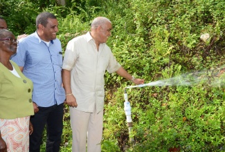 Water, Land, Environment, and Climate Change Minister, Hon. Robert Pickersgill (right), performs the symbolic commissioning of the $60 million Mile Gully/Warwick Castle water supply system in St Mary on Thursday (November 28). Sharing the moment are: President, Mile Gully/Warwick Castle Benevolent Group, Ceceline Day (left); and Member of Parliament for Western St. Mary, Joylan Silvera.