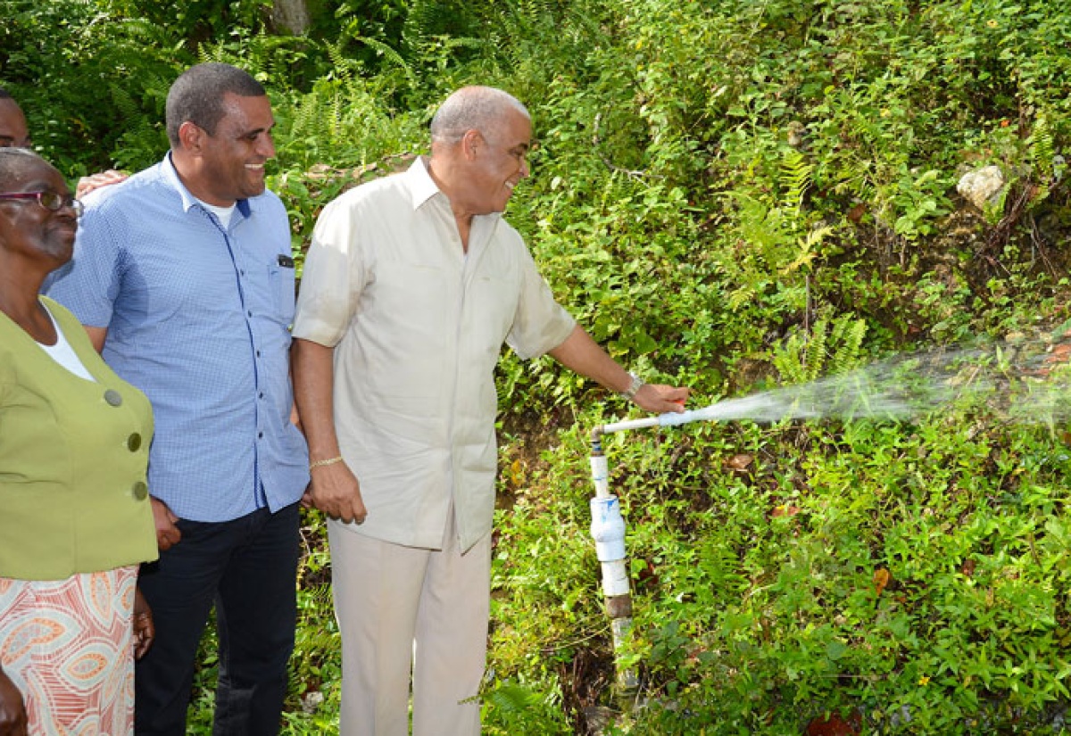 Water, Land, Environment, and Climate Change Minister, Hon. Robert Pickersgill (right), performs the symbolic commissioning of the $60 million Mile Gully/Warwick Castle water supply system in St Mary on Thursday, November 28. Sharing the moment are: President, Mile Gully/Warwick Castle Benevolent Group, Ceceline Day (left); and Member of Parliament for Western St. Mary, Joylan Silvera.