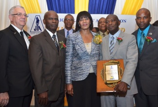 Prime Minister, the Most Hon. Portia Simpson Miller (centre); and Education Minister, Hon. Rev. Ronald Thwaites (left), shares a moment with Jamaica Teachers Association (JTA) Roll of Honour Awardee 2013, Patrick Smith (2nd right), at the award function held on February 12, at the Jamaica Pegasus Hotel, New Kingston. Others in attendance are Custos of Kingston, Hon. Steadman Fuller (2nd left); JTA President, Mark Nicely (right); 2012 Awardee Byron Farquharson (back row left); and JTA Secretary General, Dr. Adolph Cameron. 