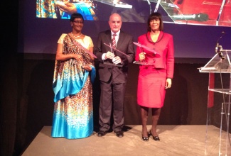 Prime Minister, the Most Hon. Portia Simpson Miller (right), proudly holds the award given to Jamaica for bridging the gender gap in terms of women in public administration, awarded by the European Union. The presentation was made during a high profile gala and awards dinner hosted by the Women In Parliaments (WIP) Global Forum, on November 27, at the Royal Museum Of Art and History in Brussels, Belgium. Speaker of the Chamber of Deputies of Rwanda, Donatille Mukabalisa (left), accepted the award on behalf of her country for Women in Parliament; while Speaker of the Senate in Ireland, Paddy Burke, accepted the award for his country, which was recognized for the number of years with Female Head of State. 