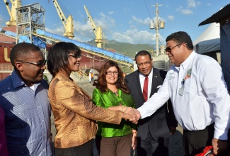 Prime Minister the Most Hon. Portia Simpson Miller (second left), congratulates General Manager, Caribbean Cement Company Limited, Anthony Haynes (right), following Thursday’s (December19) official ceremony marking the commencement of the loading exercise for the first shipment of clinker to Venezuela at the Jamaica Gypsum and Quarries Pier in Kingston, where the vessel that will transport the material was berthed. Others sharing the moment, from left, are: Minister of Science, Technology, Energy and Mining, Hon. Phillip Paulwell; Venezuelan Ambassador to Jamaica, Her Excellency, Maria Jacqueline Mendoza Ortega; and Minister of Industry, Investment and Commerce, Hon. Anthony Hylton. 