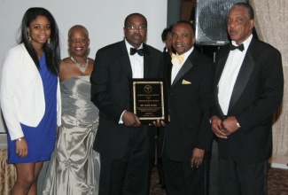 Dr. Lennox Alves (centre), displays the Caribbean Medical Mission  2013 Humanitarian Award which he accepted on behalf of the recipient, Dr. Alan Clarke,  at the Mission’s 10th fund-raising gala, held recently  in New Jersey.  Others (from right) are:  the Mission’s Fund-Raising Chairman, Lynval James; President, Dr. Winston Scott; Director, Dr. Sandra Harte and Miss Natasha Scott. 