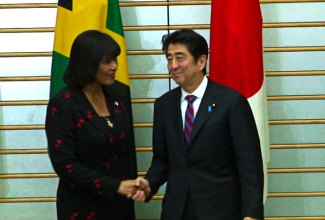 Prime Minister, the Most Hon. Portia Simpson Miller (left), is greeted by her Japanese counterpart, His Excellency Shinzo Abe, prior to their talks in Tokyo on Tuesday (November 5). Both leaders signed a statement pledging to strengthen bilateral ties between the two countries.