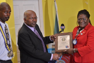 Minister with responsibility for Housing, Hon. Dr. Morais Guy (centre), is presented with a certificate of appreciation by Rotary Club of Kingston East and Port Royal member, Marcia Boyne, after delivering the main address at the club’s weekly meeting held on July 22, at the Morgan’s Harbour hotel in Port Royal. Sharing the moment is President of the Club, Howard Haughton.   