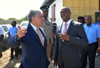 Member of Parliament for East Central St. Catherine and Minister of State in the Ministry of Foreign Affairs and Foreign Trade, Hon. Arnaldo Brown (right), looks at something being pointed out by United States Ambassador to Jamaica, Luis Moreno, at the opening of the Gregory Park Community Development Centre in St. Catherine today (November 18). The centre was constructed under the United States Agency for International Development's (USAID) Community Empowerment and Transformation Project, Phase II (COMET II).