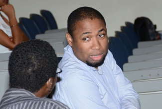 Principal Director of the National Spatial Data Management Division of the Ministry of Water, Land, Environmment and Climate Change, Rohan Richards (right), speaks with a participant during the recently held GIS Technical Seminar at the University of the West Indies, Mona Campus. Mr. Richards says the division has been working with the Office of the Children’s Registry to see how utilsing the GIS technology can help with enhancing the Ananda Alert Missing Children Recovery Programme.