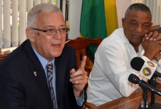 Minister of Education, Hon. Rev. Ronald Thwaites (left), addresses signing ceremony for a loan agreement with the Inter-American Development Bank (IDB) worth approximately J$3 billion to support the education sector reform, at the Ministry of Finance and Planning,  on Wednesday, November 25. Looking on is Minister of Health, Hon. Horace Dalley.