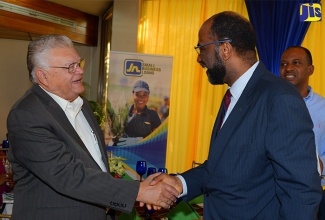 Minister of Industry, Commerce, Agriculture and Fisheries, Hon. Karl Samuda (left), is greeted by General Manager of the Jamaica National (JN)  Group, Earl Jarrett, at the Jamaica Conference Centre, where the financial institution hosted a business luncheon on December 9.