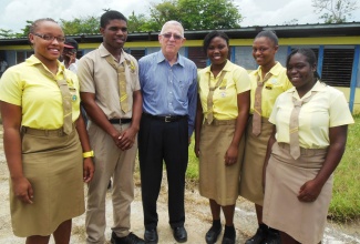 Education Minister, Hon. Rev. Ronald Thwaites (3rd left), interfaces with Grade 10 students of Anchovy High School in St. James, from left: Anesia Eldermire, Kijori Harris, Keneisha Harvey, Dacia Vincent and Crystal Smith, following Friday’s (June 20) groundbreaking ceremony at Montpelier, St. James, where the institution’s second campus will be established. Rev. Thwaites delivered the keynote address.