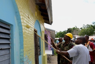 Members of the Jamaica Defence Force (JDF) Engineering Regiment are assisted by several residents of Port Maria and its environs in painting the St. Mary Infirmary’s multipurpose building, during Thursday’s (May 23) Labour Day activities at the institution, designed the national project. Labour Day was observed under the theme: ‘Lend a Hand…Build our Land’.