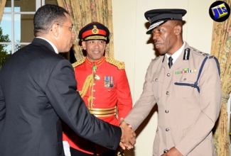 Prime Minister, the Most Hon. Andrew Holness (left), is greeted by  Police Commissioner, Dr. Carl Williams (right). Looking on is Chief of  Defence Staff (CDS), Major General Antony Anderson.