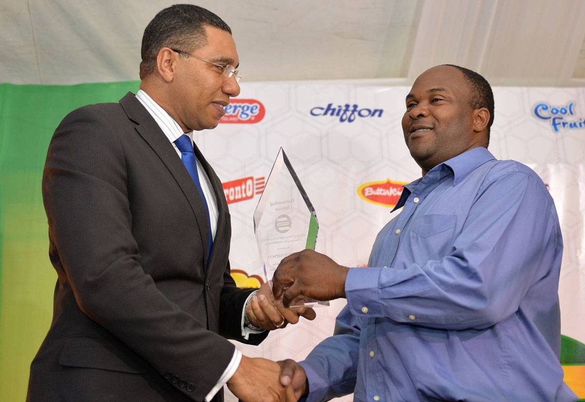 Prime Minister, the Most Hon. Andrew Holness (left), presents Machine Operator at International Biscuits Limited (IBL),  Ian Thompson, with an award of appreciation for his gallantry in risking his life to protect the assets of the company when he discovered a fire at facility. The presentation was made today (April 27), during the unveiling ceremony for new factory equipment at the IBL facility, in St. Andrew. SEPROD has made an investment of $285 million in state-of-the-art food manufacturing equipment, including the latest oven technology. IBL is a member of the SEPROD Group.