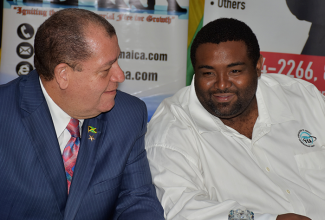 Finance and the Public Service Minister, Hon. Audley Shaw (left), speaks with Young Entrepreneurs Association of Jamaica (YEA) President, Ricardo James, at a policy proposal forum staged by the association on April 12 at the Jamaica Promotions Corporation (JAMPRO) headquarters in New Kingston.